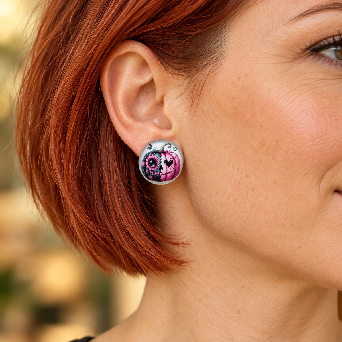 Tragebild: Ohrringe grau mit pink grauem Kürbis, 20 mm, am Ohr einer Frau.