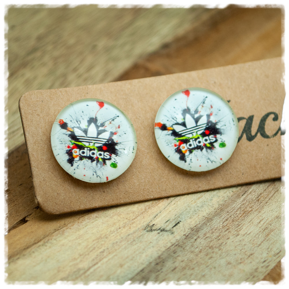 Ohrringe in 20 mm mit Adidas-Schriftzug und schwarzen Farbspritzern