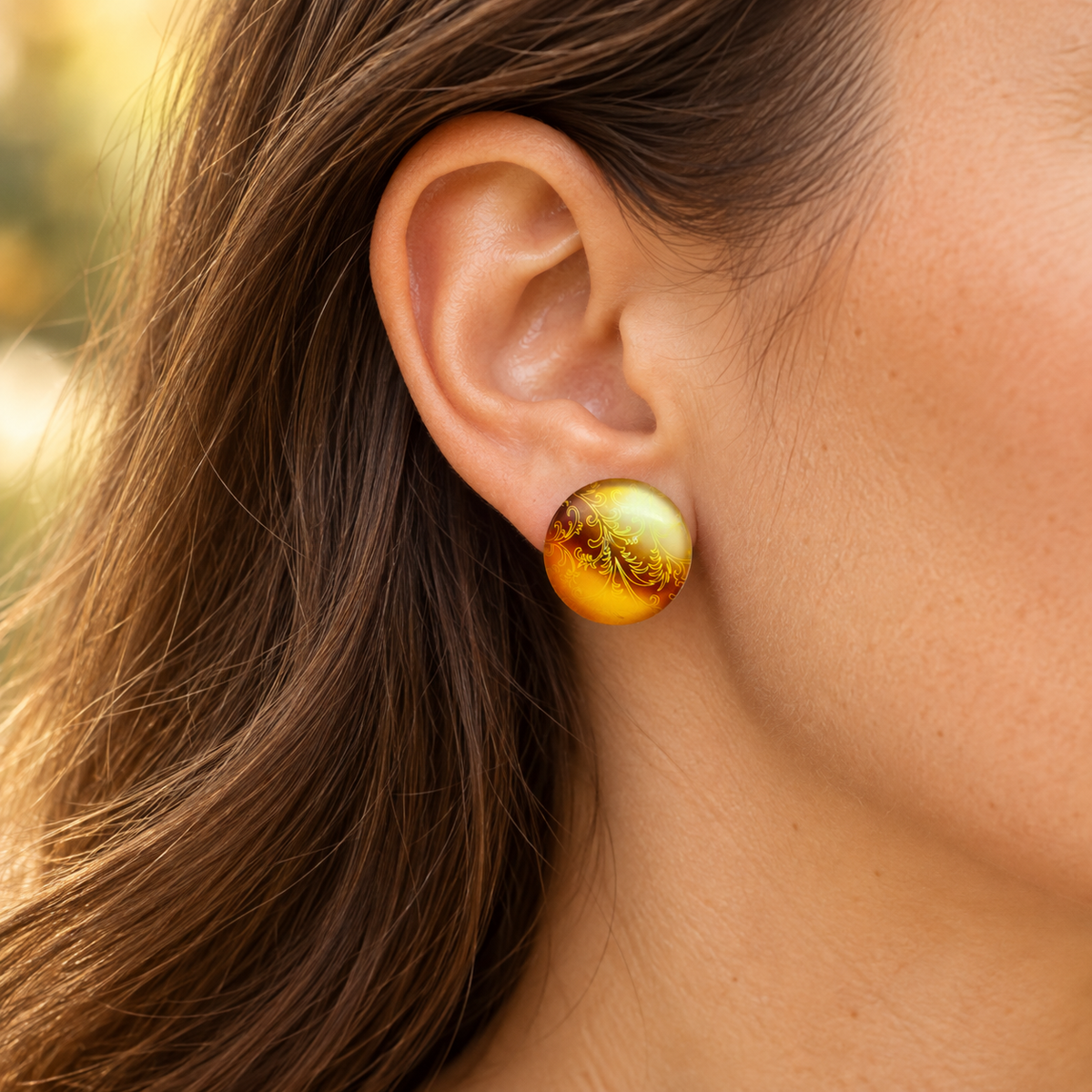 Tragebild: Ohrringe golden mit goldenen Ornamenten, 20 mm, am Ohr einer Frau.