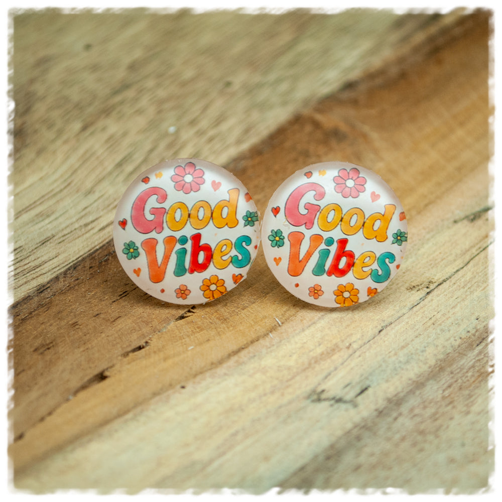 Jackelina Ohrstecker mit buntem Schriftzug Good Vibes, Blumen und Herzen, als Paar auf Holz fotografiert